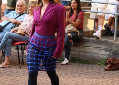 Modella in passerella con completo viola e gonna dalla struttura reticolare blu per CIRT EDU.